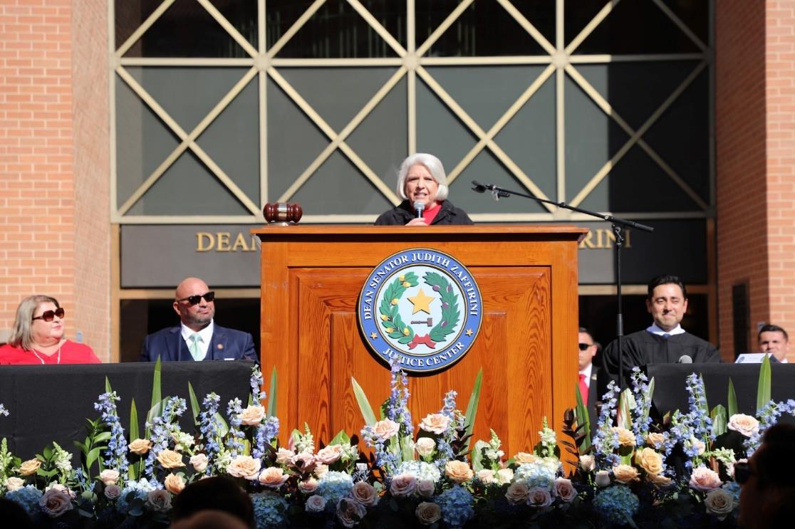 Photo: Dean Senator Judith Zaffirini addresses the audience at the dedication ceremony of the Dean Senator Judith Zaffirini Justice Center in Webb County. Stage guests included (L-R) Commissioner Rosaura “Wawi” Tijerina, County Judge Tano Tijerina and Judge Victor Villarreal.